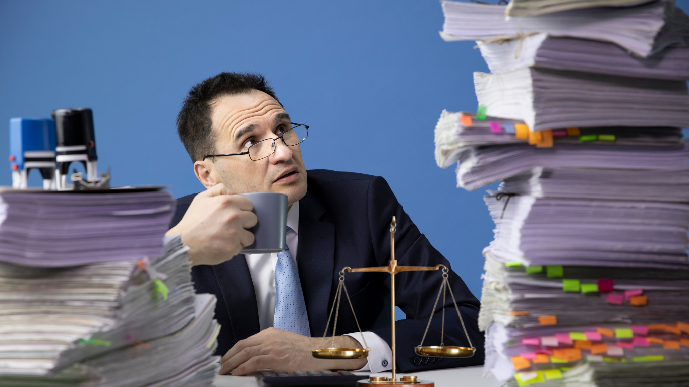 An overwhelmed executor reviewing a pile of legal documents and real estate paperwork, symbolizing the challenges of probate real estate.